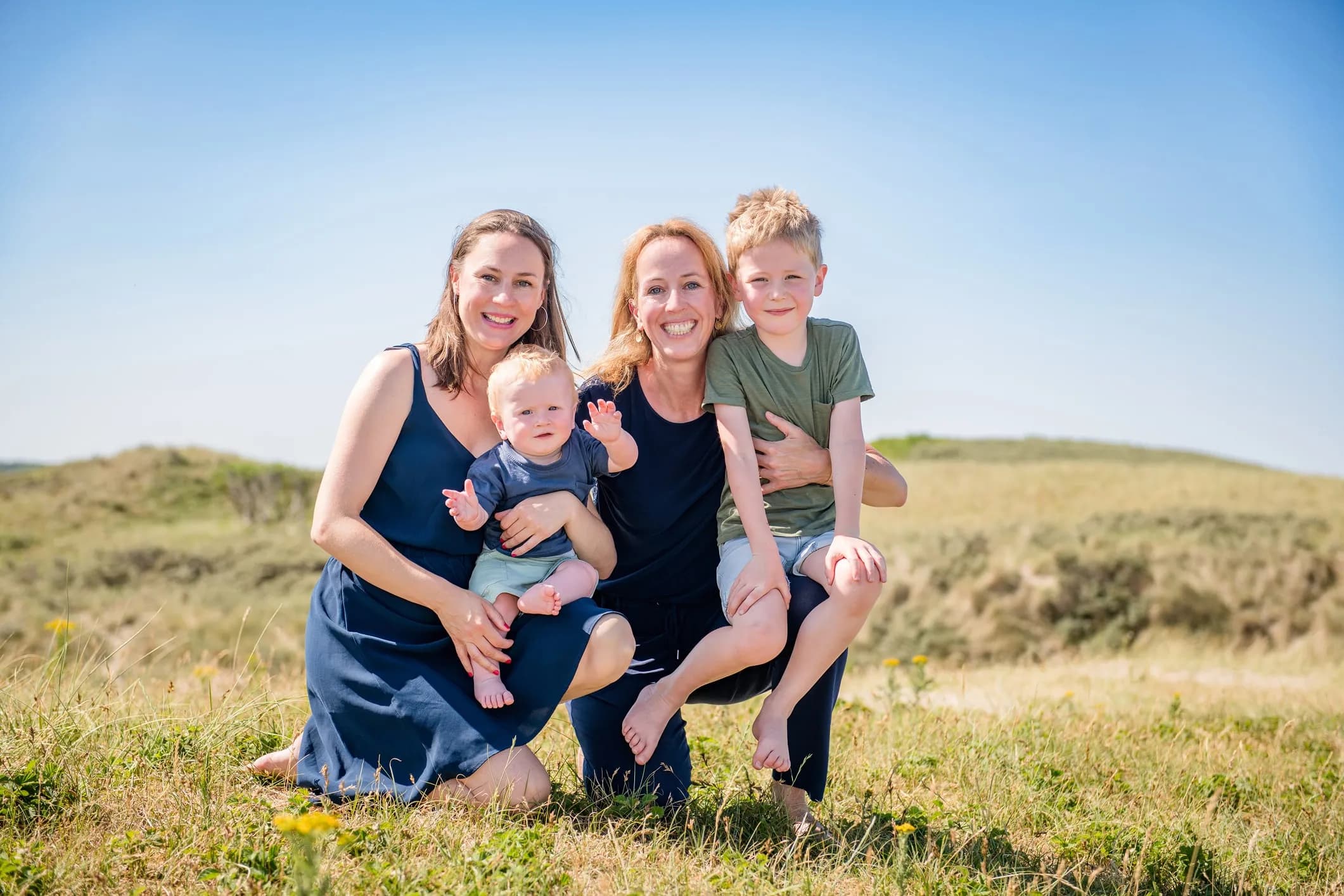 Familiefoto van twee moeders met hun kinderen in de duinen