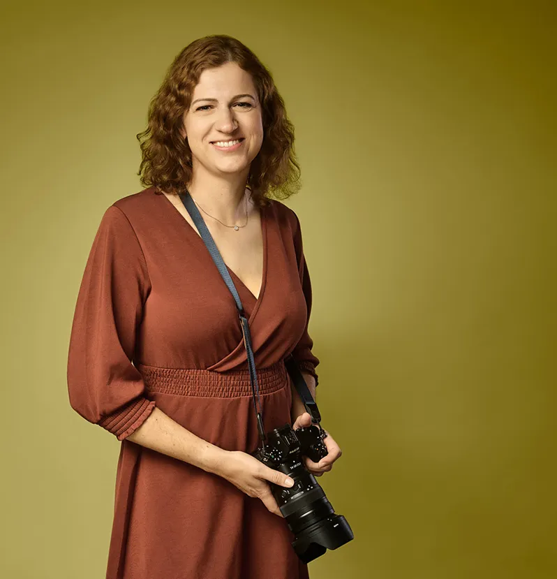 Joanna Vunderink met haar camera, in een roestbruine jurk